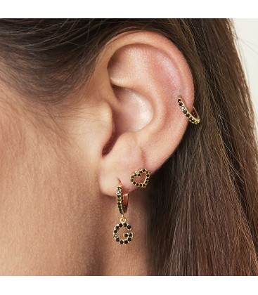 Goudkleurige oorbel met zwarte steentjes en hanger met de letter G