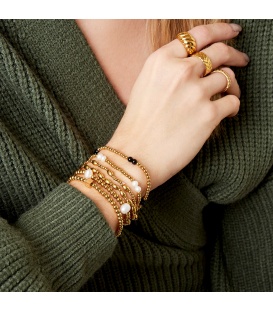 Elastische armband met goudkleurige kralen en parels