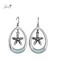 Mooie ovale zilverkleurige oorbellen met hanger in de vorm van een zeester