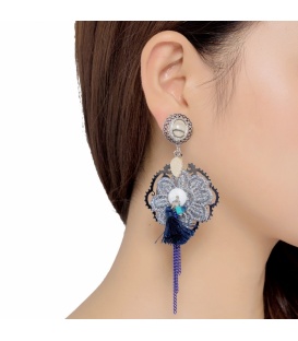 Zilverkleurige oorclips met een grijze stoffen bloem en blauwe kwast en paarse strengen