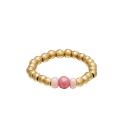 Teenring met goudkleurige kralen en drie lichtroze stenen