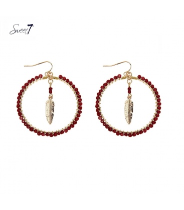 Goudkleurige oorhangers met een bedel en rode kraaltjes