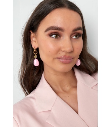 Goudkleurige oorhangers met als bedel een hartje en een roze steentje