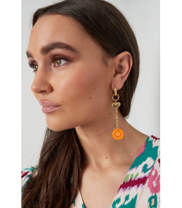 Goudkleurige oorhangers met hartje en een oranje smiley