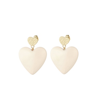 Beige harten oorhangers en een goudkleurig hartje