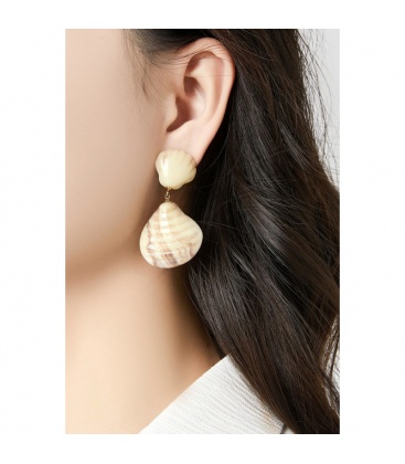 Creme oorclips met een schelpen motief gemaakt van hars