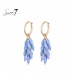 Goudkleurige oorringen met blauwe glas kralen als hanger