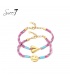 Roze gekleurde armbanden met een goudkleurige smily en een hart