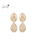 Beige oorhangers met een cat eye stenen en een goudkleurige rand