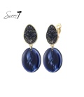 Blauwe oorclips met een ovale hanger en glas steentjes