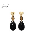 Oorbellen zwart met cat eye steen en goudkleurig hart