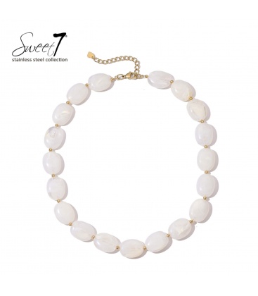 Halsketting met witte kralen en gouden details, elegant en modern.