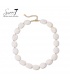 Halsketting met witte kralen en gouden details, elegant en modern.