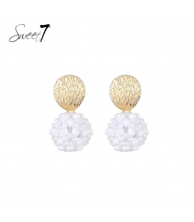 Oorbellen met goudkleurige schijf en witte kralenbol.