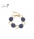 Armband met donkerblauwe schijfjes, stippen en goudkleurige schakels.